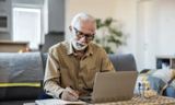 Senior man going over finances using his laptop